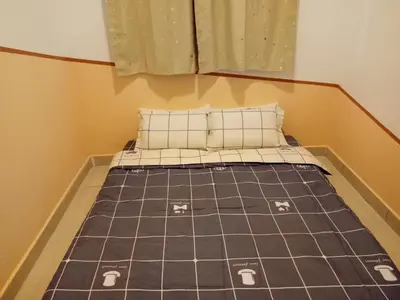 a bed with two pillows on it in a room at ICOLOR HOME & STAY CH1 in Tanah Rata