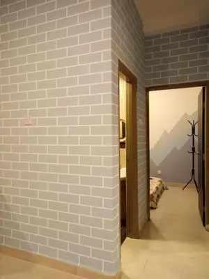 a room with a brick wall and a view of a bedroom at ICOLOR HOME & STAY CH2 in Tanah Rata