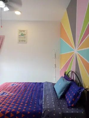 a bedroom with a bed and a colorful wall at ICOLOR HOME & STAY CH3 in Tanah Rata