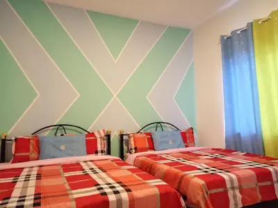 two beds sitting next to each other in a room at ICOLOR HOME & STAY CH3 in Tanah Rata