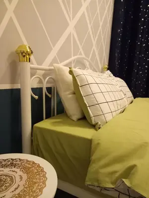 a bed with green sheets and pillows on it at ICOLOR HOME & STAY CH4 in Tanah Rata