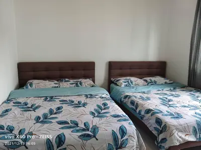 two beds sitting next to each other in a bedroom at ICOLOR HOME & STAY CH4 in Tanah Rata
