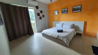 a bedroom with a bed with a suitcase on it at By The Sea Beach Luxury Resort - Batu Ferringhi in Batu Ferringhi