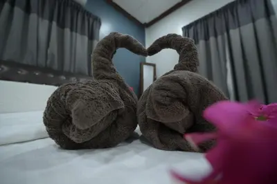two stuffed animals are sitting on a bed at Hotel Denai in Gua Musang