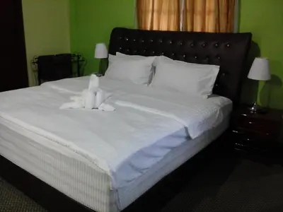 a white teddy bear sitting on top of a bed at Hotel Denai in Gua Musang