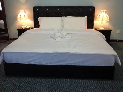 a stuffed animal is sitting on a bed at Hotel Denai in Gua Musang