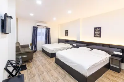a hotel room with two beds and a tv at Tambun Warm Hotel in Ipoh