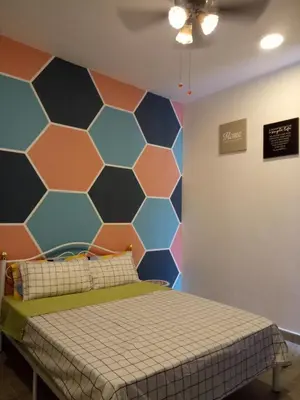 a bedroom with a hexagonal wall at ICOLOR HOME & STAY CH5 in Tanah Rata