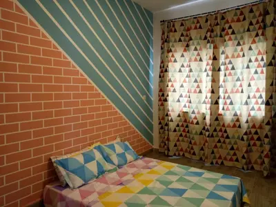a bedroom with a bed and a brick wall at ICOLOR HOME & STAY CH5 in Tanah Rata
