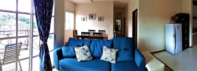a blue couch with pillows in a living room at Teaz Apartment @ Iris House Resort in Cameron Highlands