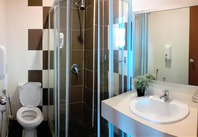 a bathroom with a toilet and a sink and a shower at Teaz Apartment @ Iris House Resort in Cameron Highlands