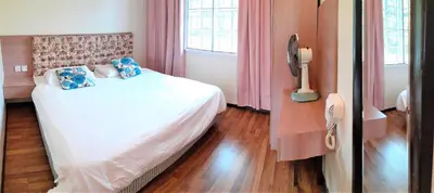 a bedroom with a white bed with blue pillows at Teaz Apartment @ Iris House Resort in Cameron Highlands