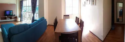 a living room with a wooden table and blue chairs at Teaz Apartment @ Iris House Resort in Cameron Highlands