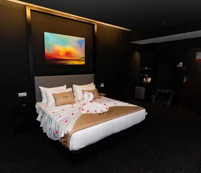 a bedroom with a large bed with a painting on the wall at Artworks Hotel Ipoh in Ipoh