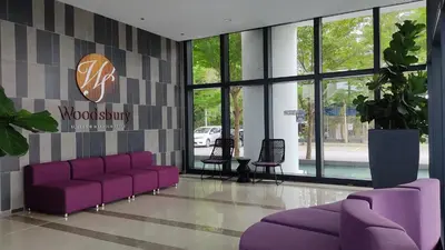 a lobby with purple couches and a sign on the wall at Mevin Woodsbury Suite Butterworth Penang in Butterworth