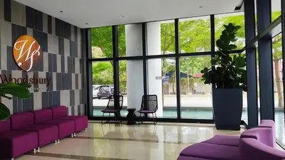 a lobby with purple couches and a potted plant at Mevin Woodsbury Suite Butterworth Penang in Butterworth
