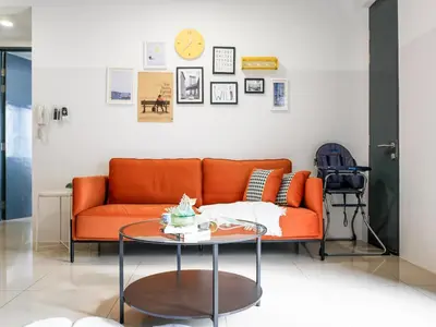 an orange couch in a living room with a table at Casita 22, 218 Macalister Georgetown City & Seaview in George Town