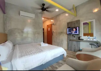 a bedroom with a bed and a tv on a wall at Rick Resort Teluk Intan in Teluk Intan
