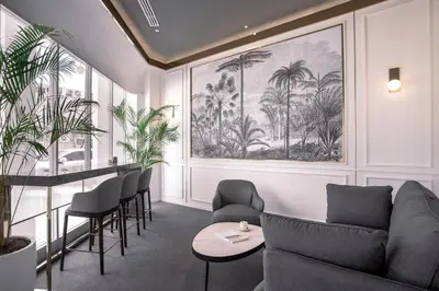 a waiting room with a couch and chairs and palm trees at The Prestige Hotel Penang, a Member of Design Hotels in George Town