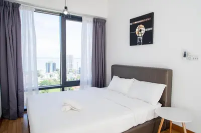 a bedroom with a white bed with a large window at Tropicana 218 MACALISTER in George Town