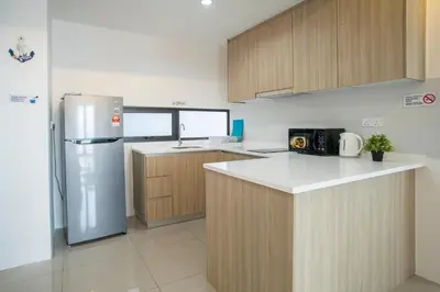 a kitchen with wooden cabinets and a stainless steel refrigerator at Tropicana 218 MACALISTER in George Town