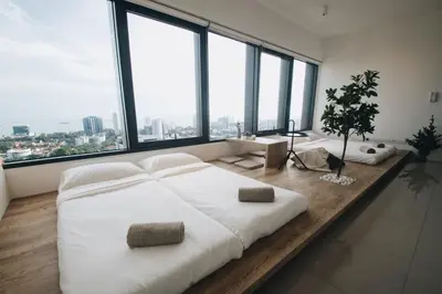 a bedroom with a large white bed and large windows at Tropicana 218 MACALISTER in George Town