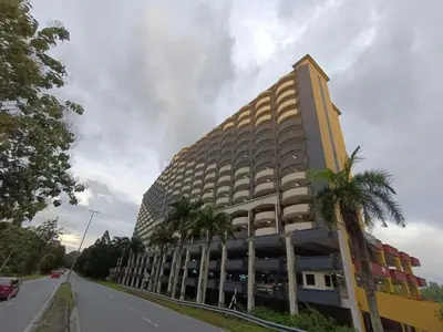 a building on the side of a street with palm trees at Desair Apartment By SCHT in Lumut