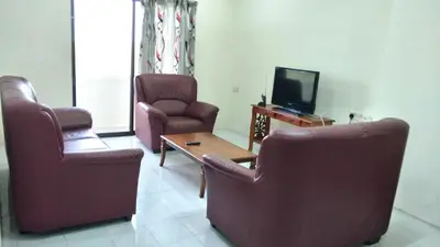 a living room with two chairs and a tv at Desair Apartment By SCHT in Lumut