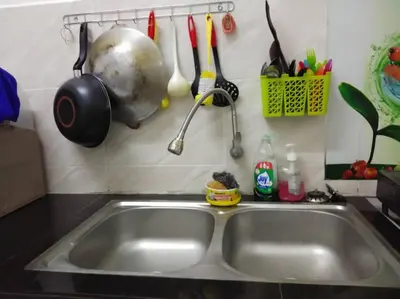 a kitchen sink with utensils hanging above it at Zah’ra Homestay in Kuala Lipis