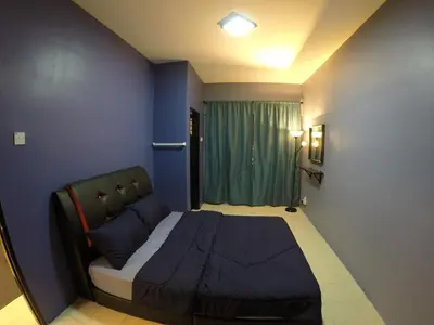 a small bedroom with a bed and a blue wall at Qasturi Homestay Cameron in Cameron Highlands