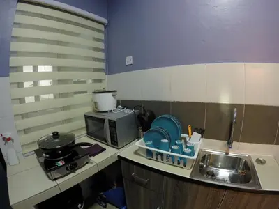 a small kitchen with a sink and a microwave at Qasturi Homestay Cameron in Cameron Highlands
