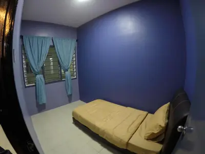 a small bedroom with a bed in a blue wall at Qasturi Homestay Cameron in Cameron Highlands