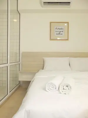 a bedroom with a white bed with towels on it at Minima 8 in George Town