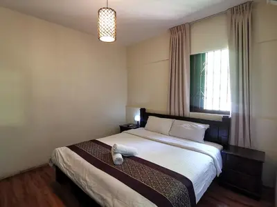 a bedroom with a large bed with a pillow on it at 8 Boutique By The Sea in George Town