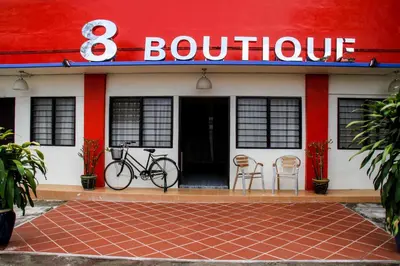 a red and white building with a bike parked outside at 8 Boutique By The Sea in George Town