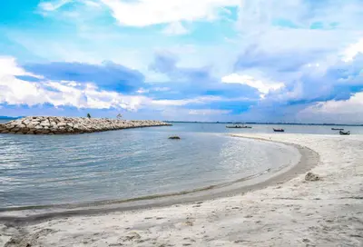 a beach with a rocky island in the water at 8 Boutique By The Sea in George Town