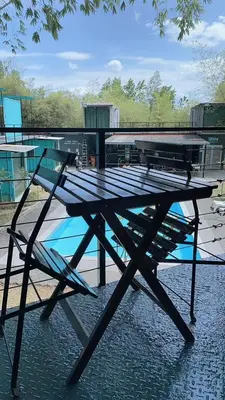 a picnic table with a chair sitting next to a pool at Sarang by the brook in Kuala Kubu Baharu