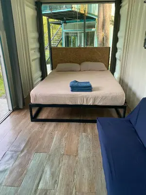 a bedroom with a bed and a wooden floor at Sarang by the brook in Kuala Kubu Baharu