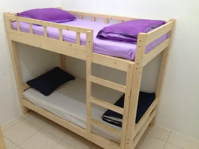a wooden bunk bed with purple pillows on it at NUHA HOMESTAY in Seri Iskandar