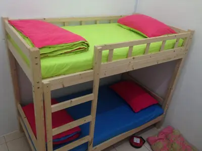 a wooden bunk bed with colorful sheets and pillows at NUHA HOMESTAY in Seri Iskandar