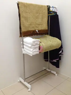 a towel rack with a bunch of clothes on it at NUHA HOMESTAY in Seri Iskandar