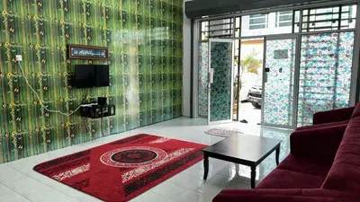 a living room with a red couch and a table at GERIK HOMESTAY in Gerik