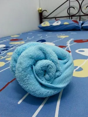 a blue towel sitting on top of a bed at GERIK HOMESTAY in Gerik