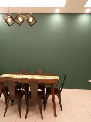 a dining room table with chairs and a green wall at NATURE @ FOREST CAMERON 15 in Tanah Rata
