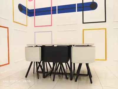 a table and chairs in front of a wall with art at CLASSIC ENGLISH @ CH in Tanah Rata