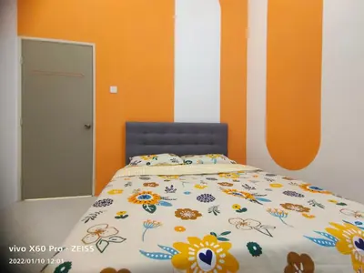 a bedroom with a bed with flowers on it at CLASSIC ENGLISH @ CH in Tanah Rata