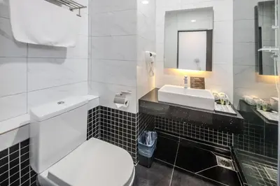 a bathroom with a white toilet and a sink at O&G Hotel Parit Buntar in Parit Buntar