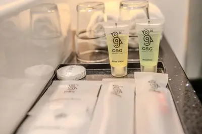 a table with two bottles of moisturizing cream and glasses at O&G Hotel Parit Buntar in Parit Buntar