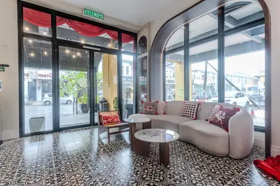 a living room with a couch and tables and windows at O&G Hotel Parit Buntar in Parit Buntar
