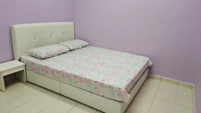 a small bed in a room with a purple wall at Muslim Dinaim Homestay in Tanjung Malim